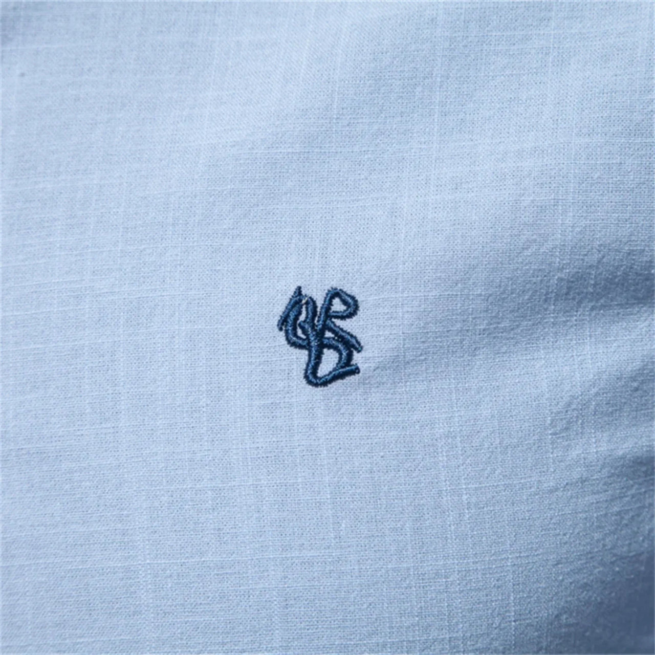 Light blue fabric with a small embroidered logo in the center