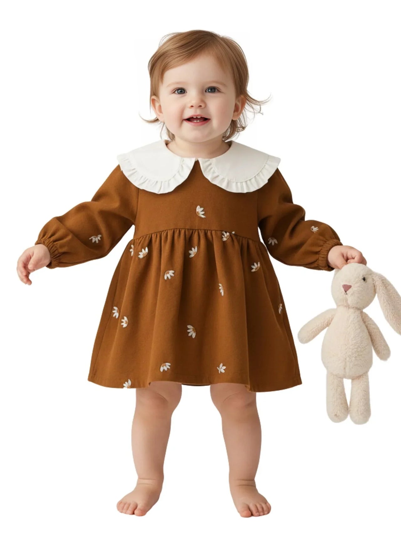Child wearing a brown dress with white collar holding a plush toy on a white background
