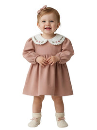 Thumbnail for Child wearing a pink dress with a white collar on a white background