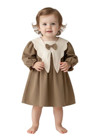 Thumbnail for Child wearing a brown dress with a white collar and bow on a white background