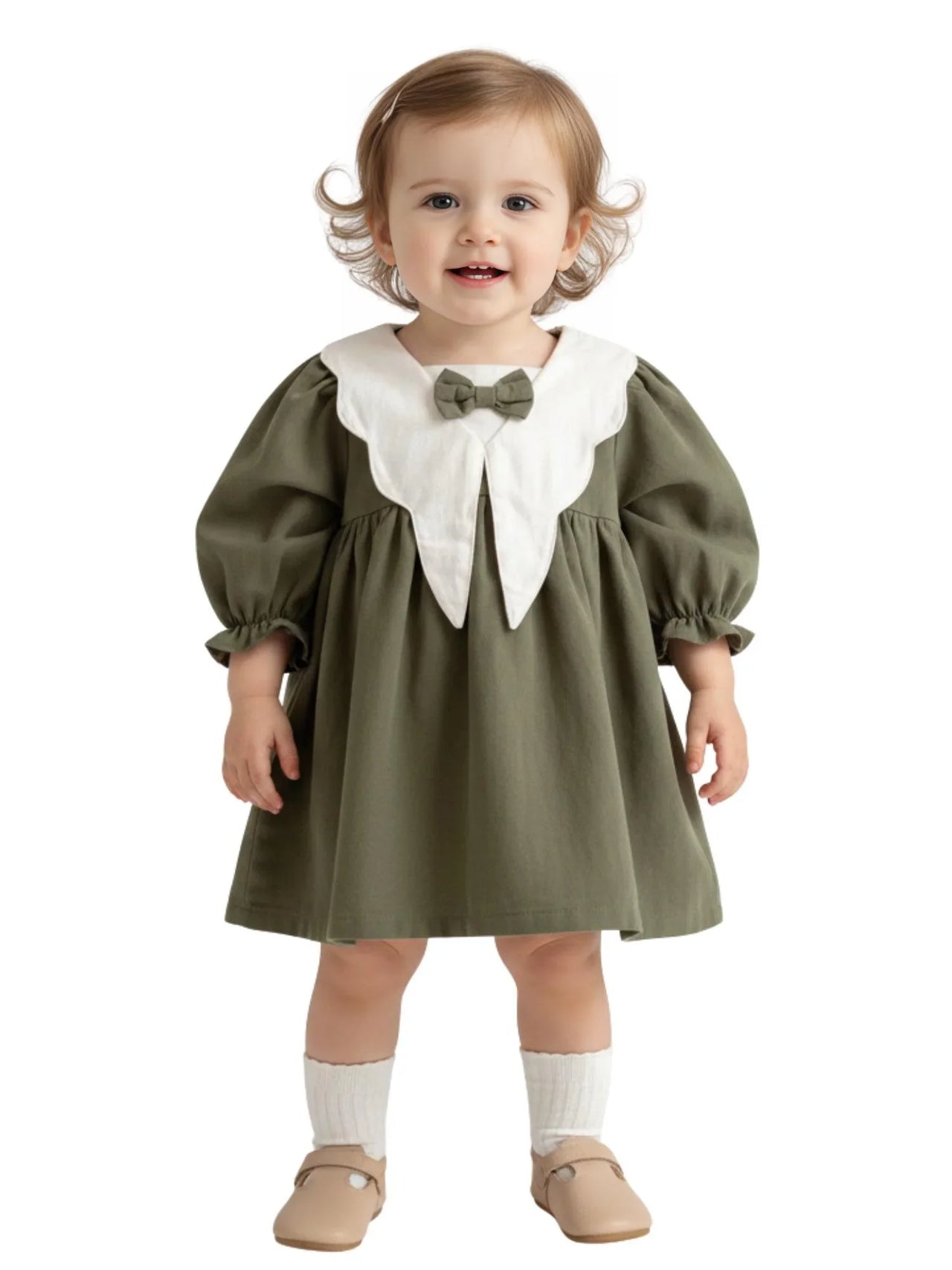 Child wearing a green dress with a white collar and bow tie on a white background