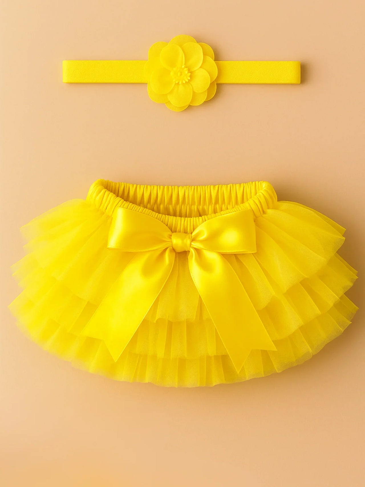 Yellow tutu skirt with matching headband on a beige background