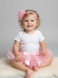 Thumbnail for Child wearing a pink tutu and headband against a gray background