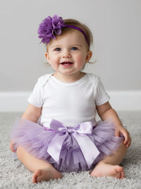 Thumbnail for Baby wearing a white outfit with a purple tutu and headband on a gray background