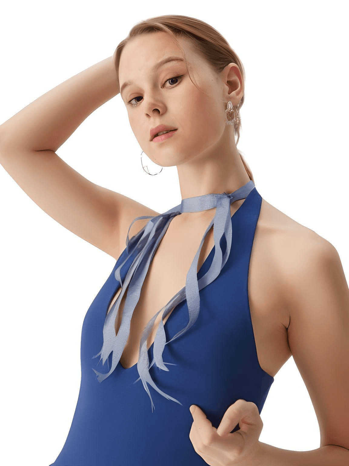 Woman wearing a blue halter neck dress with ribbon details on a white background