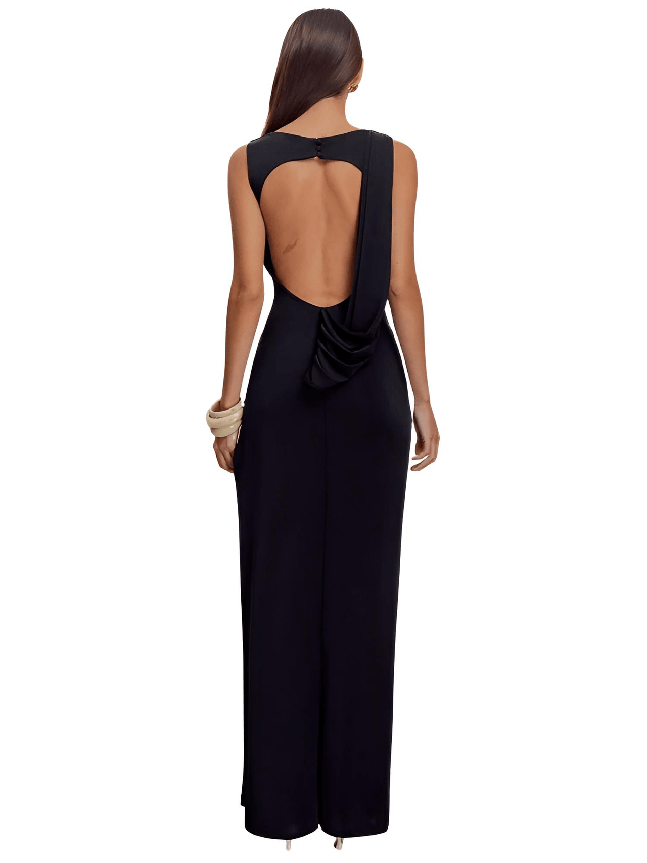Woman wearing a black evening gown with an open back on a white background