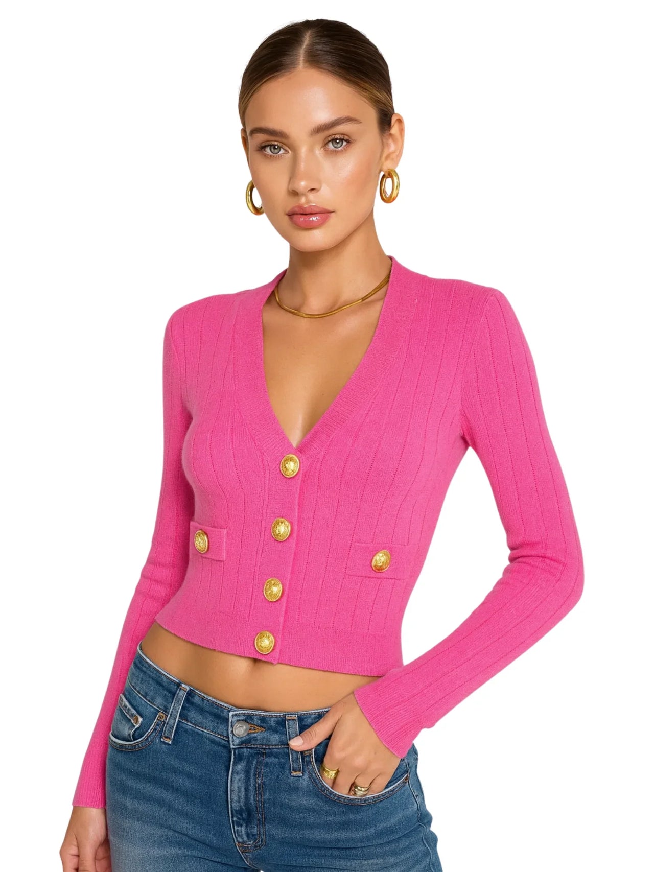 Woman wearing a pink cardigan with gold buttons on a white background