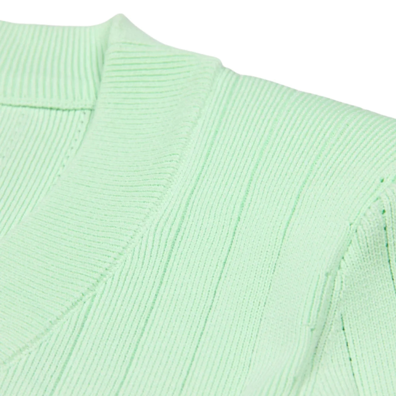 Close-up of a light green ribbed sweater on a white background