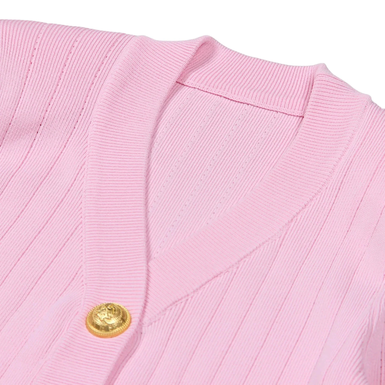 Close-up of a pink cardigan with a gold button on a white background