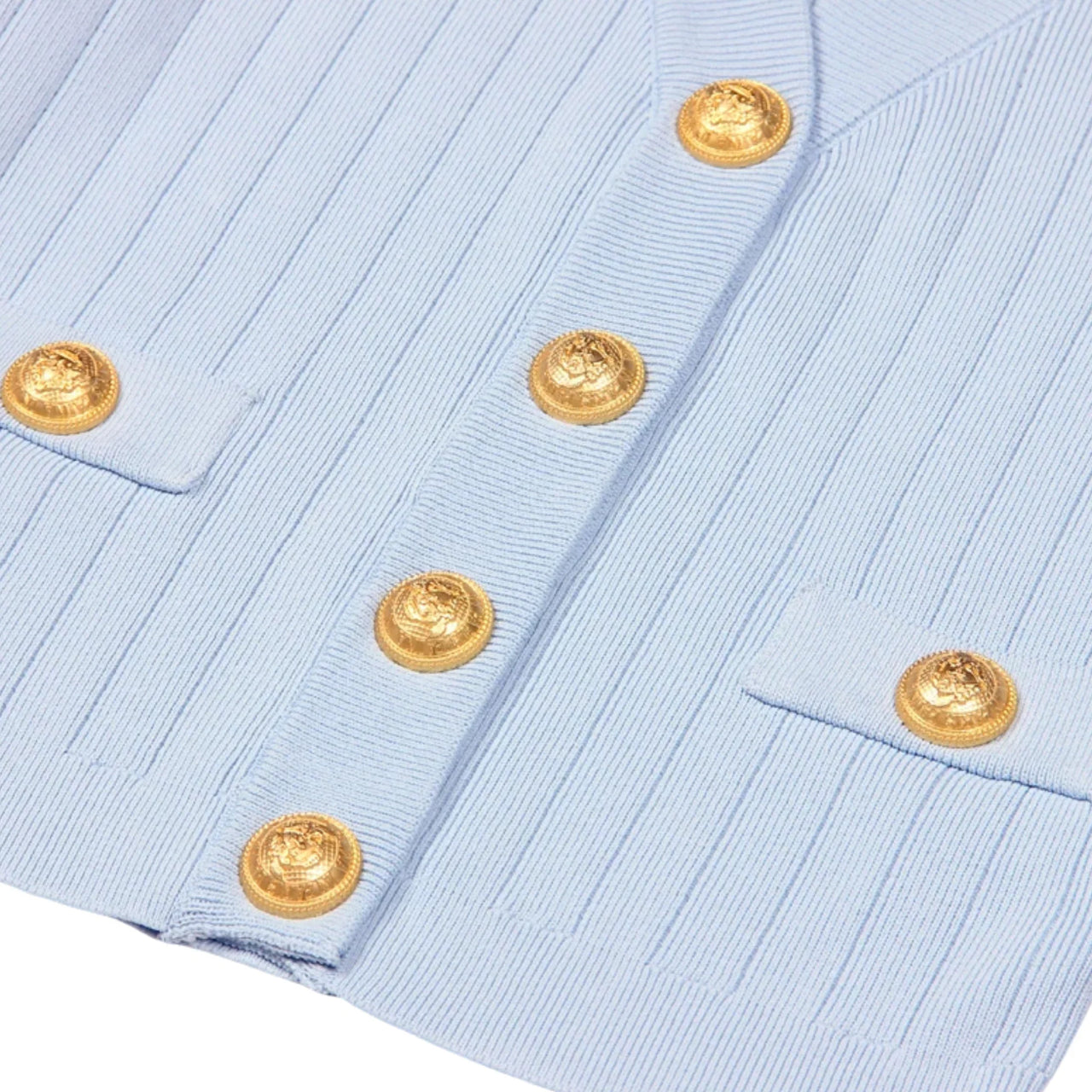 Light blue shirt with gold buttons on a white background