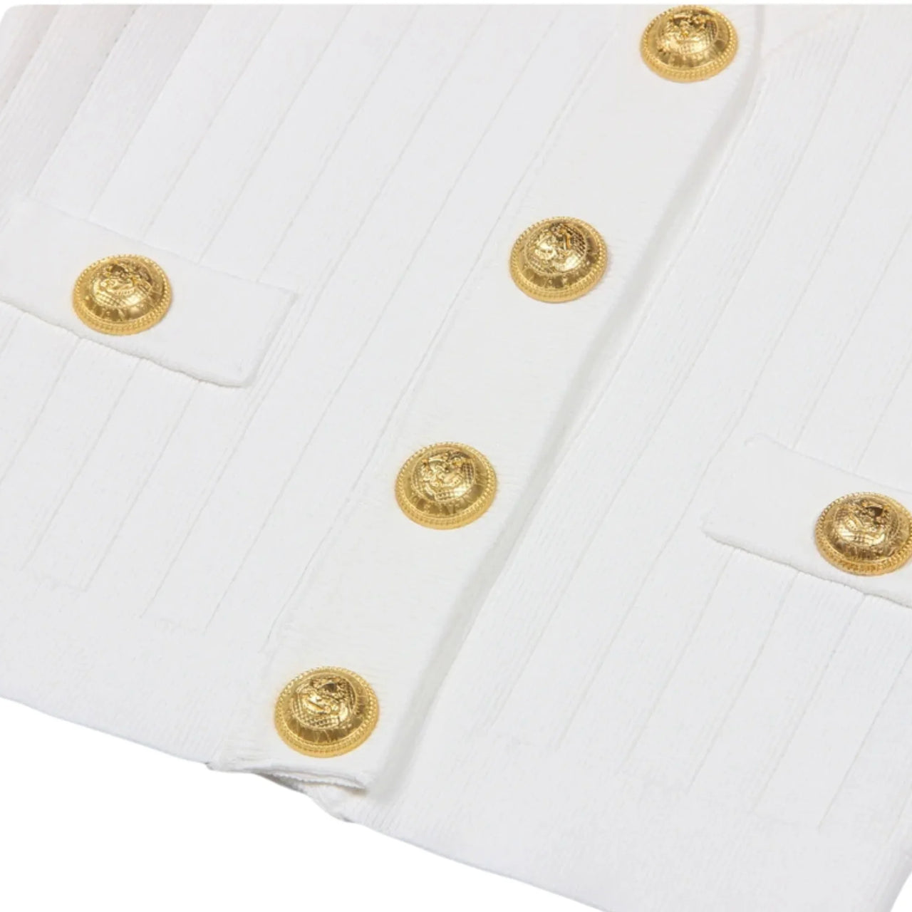 Close-up of a white garment with gold buttons