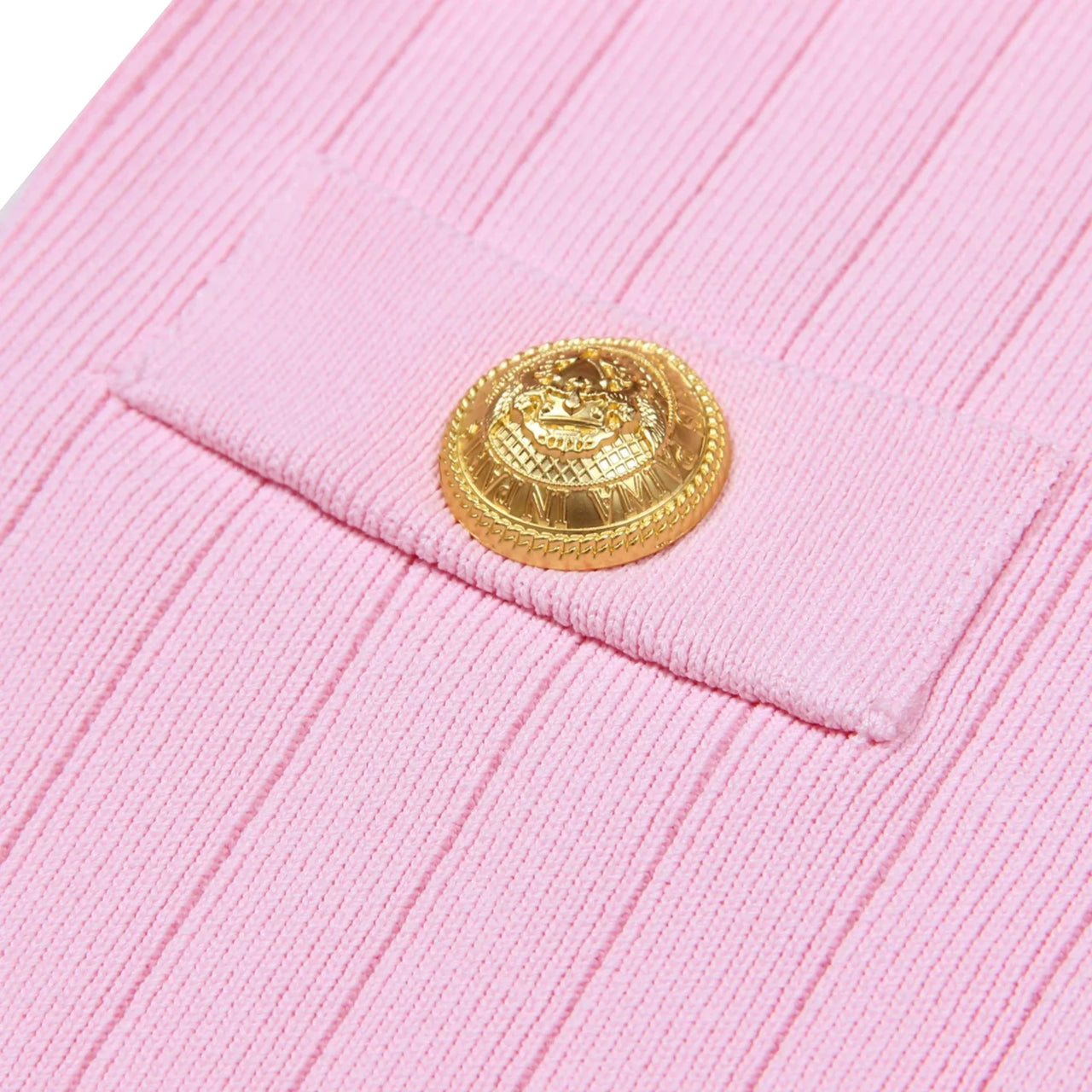 Close-up of a pink cardigan with a gold button on a white background