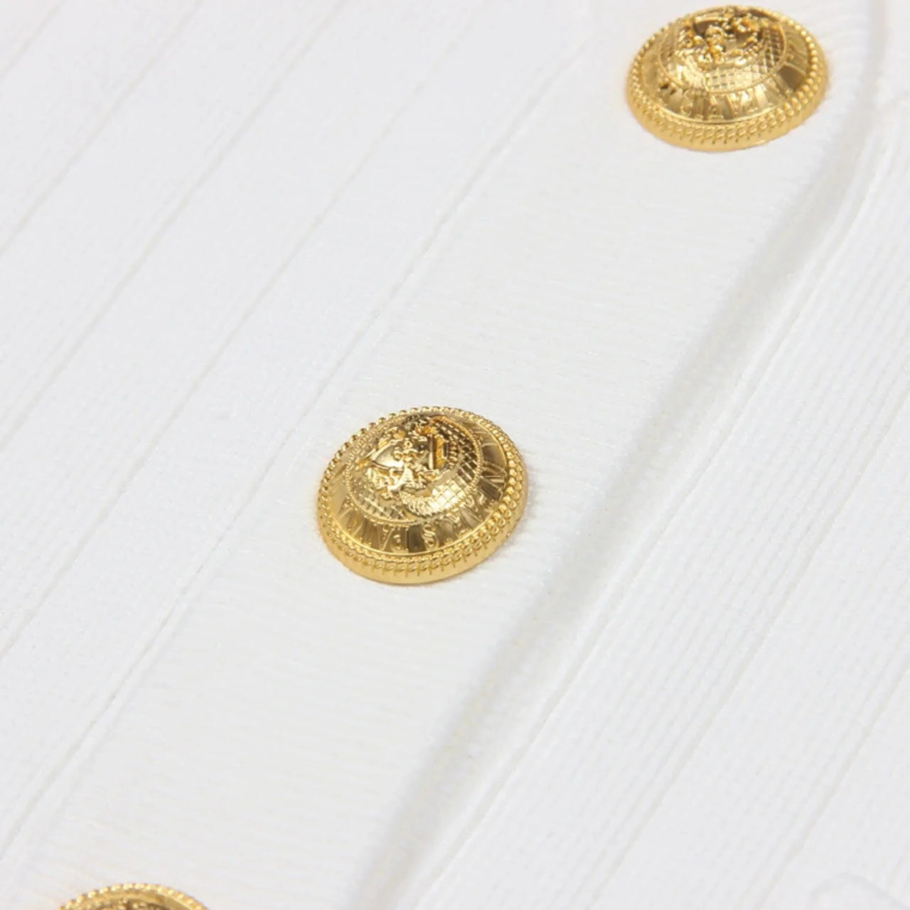 Gold buttons on a white textured fabric background