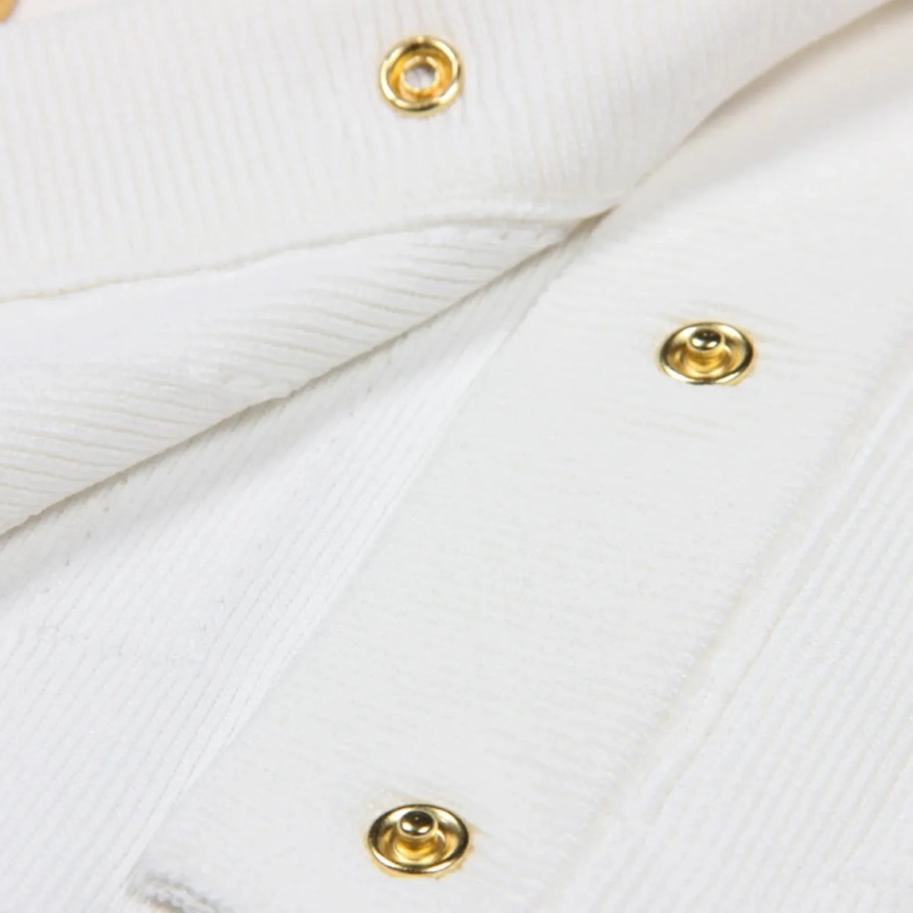 Close-up of a white fabric with gold buttons