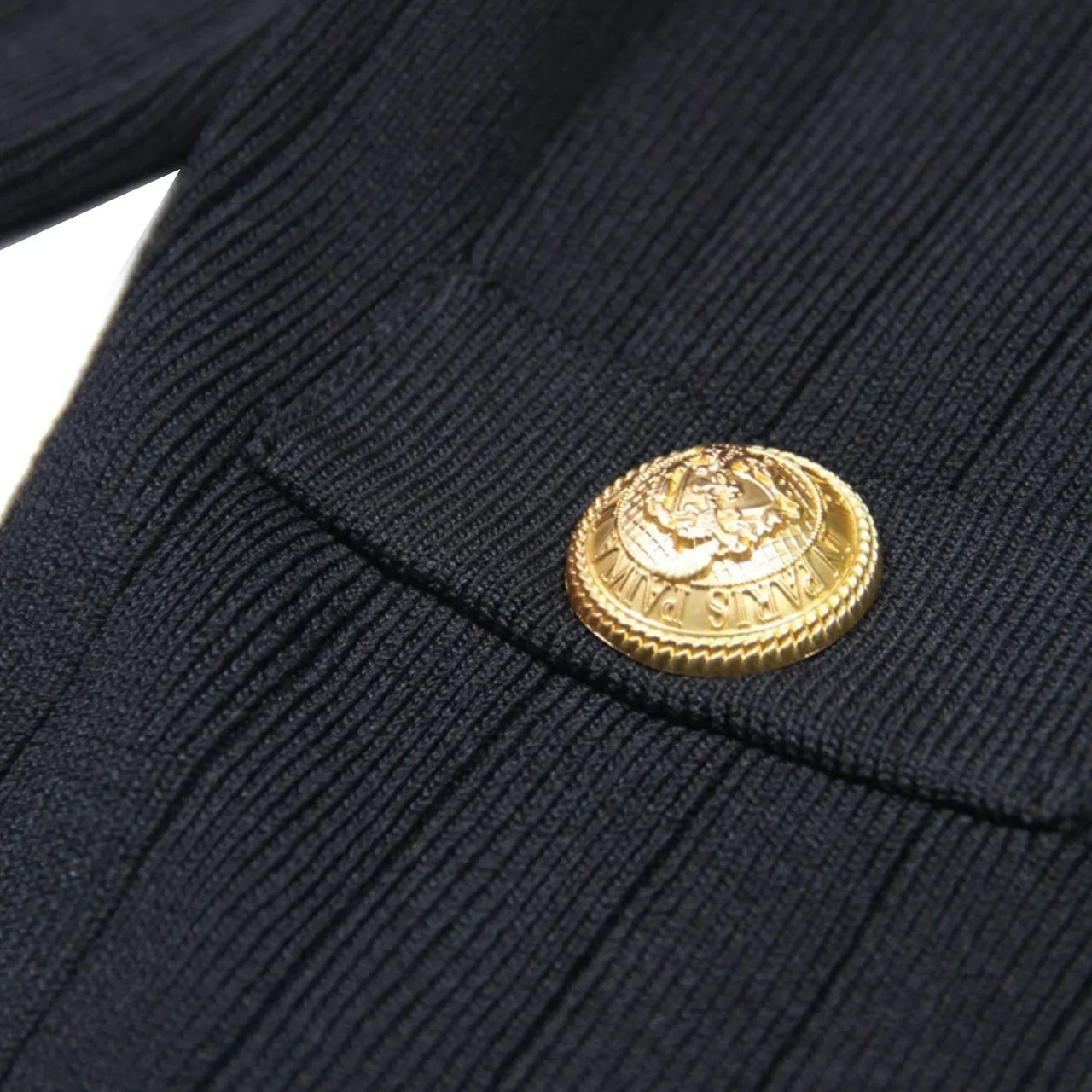Close-up of a gold button on a dark blue fabric background