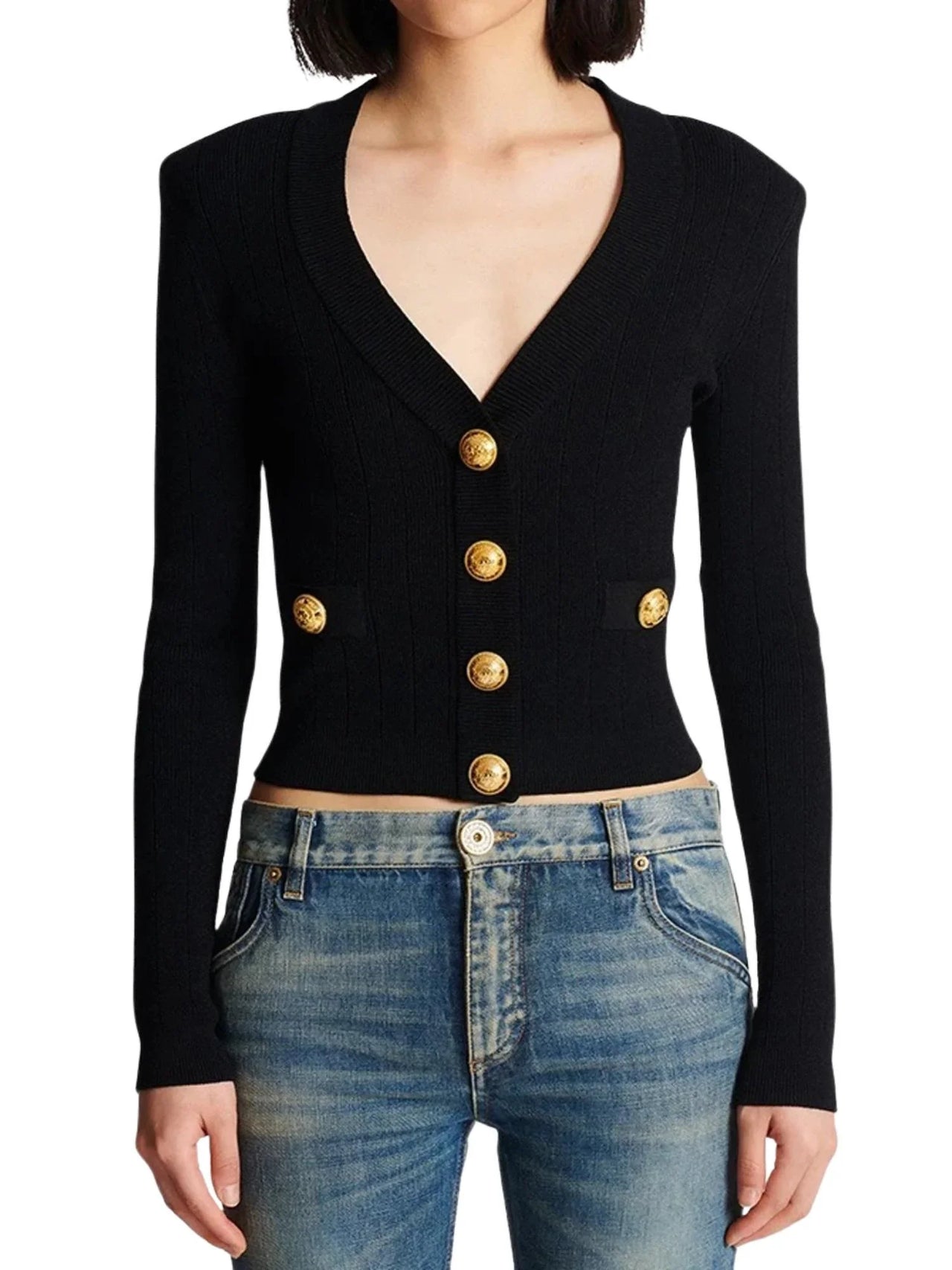 Black cardigan with gold buttons worn by a woman on a white background