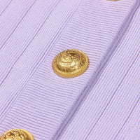 Thumbnail for Close-up of a light purple cardigan with a gold button on a white background