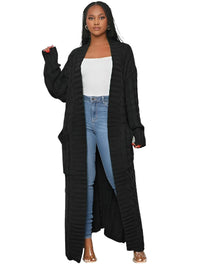 Thumbnail for Woman wearing a long black cardigan over a white top and blue jeans on a white background