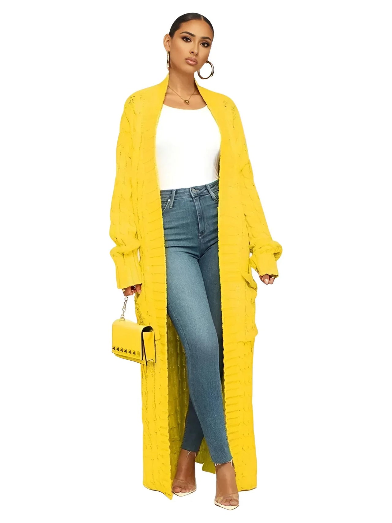 Woman wearing a long yellow cardigan with a white top and blue jeans on a white background
