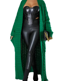 Thumbnail for Woman wearing a green cardigan over a black outfit with a gold chain detail.