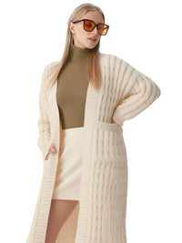 Thumbnail for Woman wearing a long beige cardigan, brown turtleneck, and white skirt on a white background