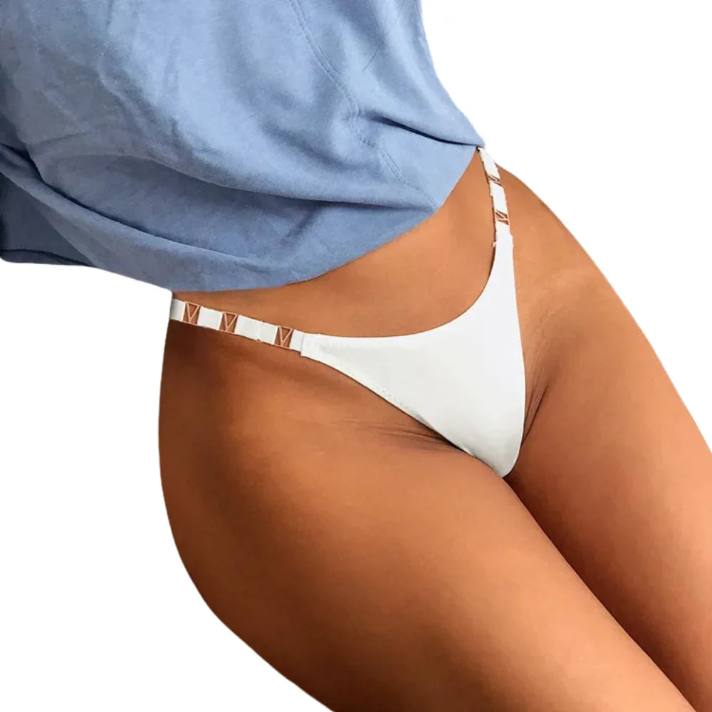 Person wearing a blue shirt and white thong panties on a white background