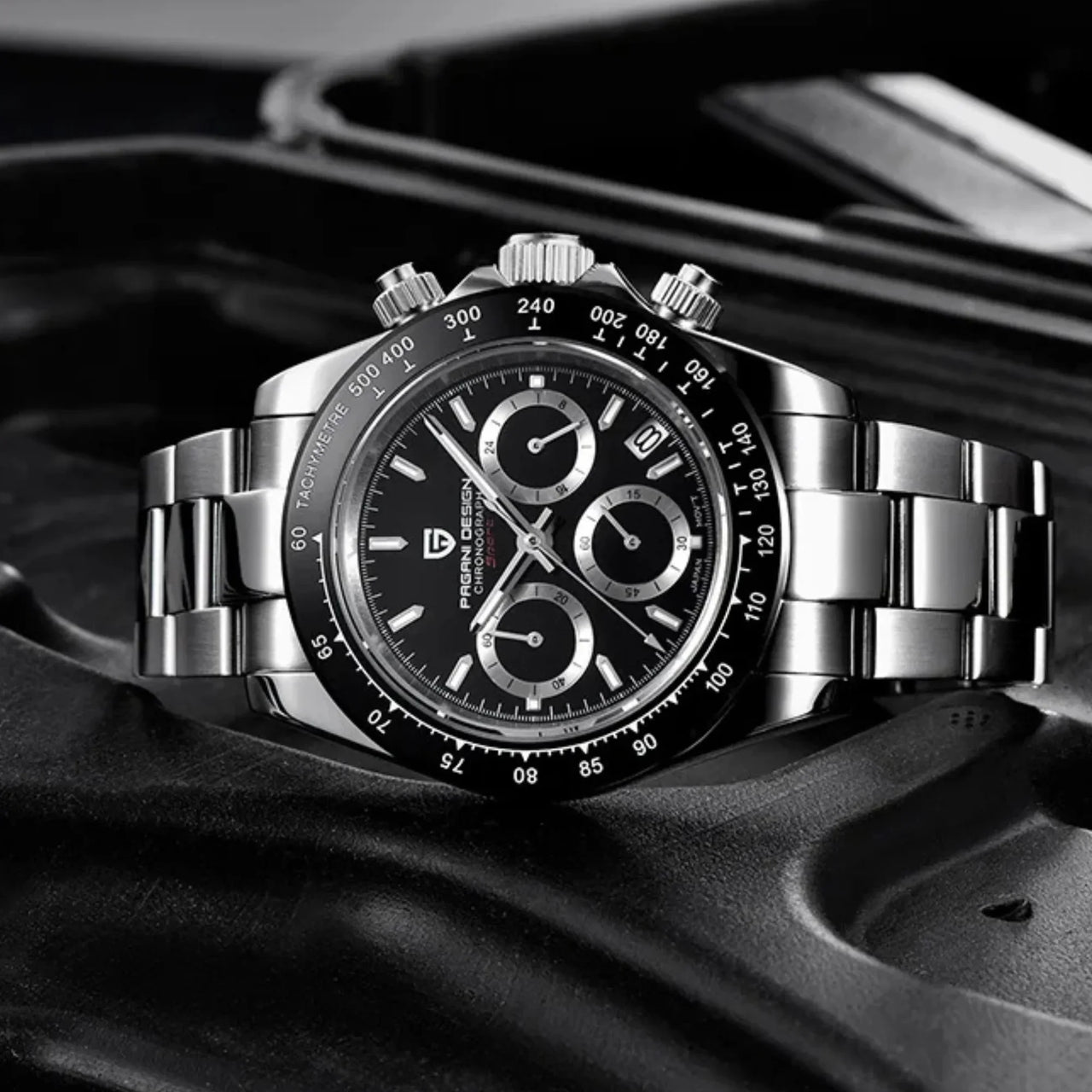 Silver watch with black dial on a dark background