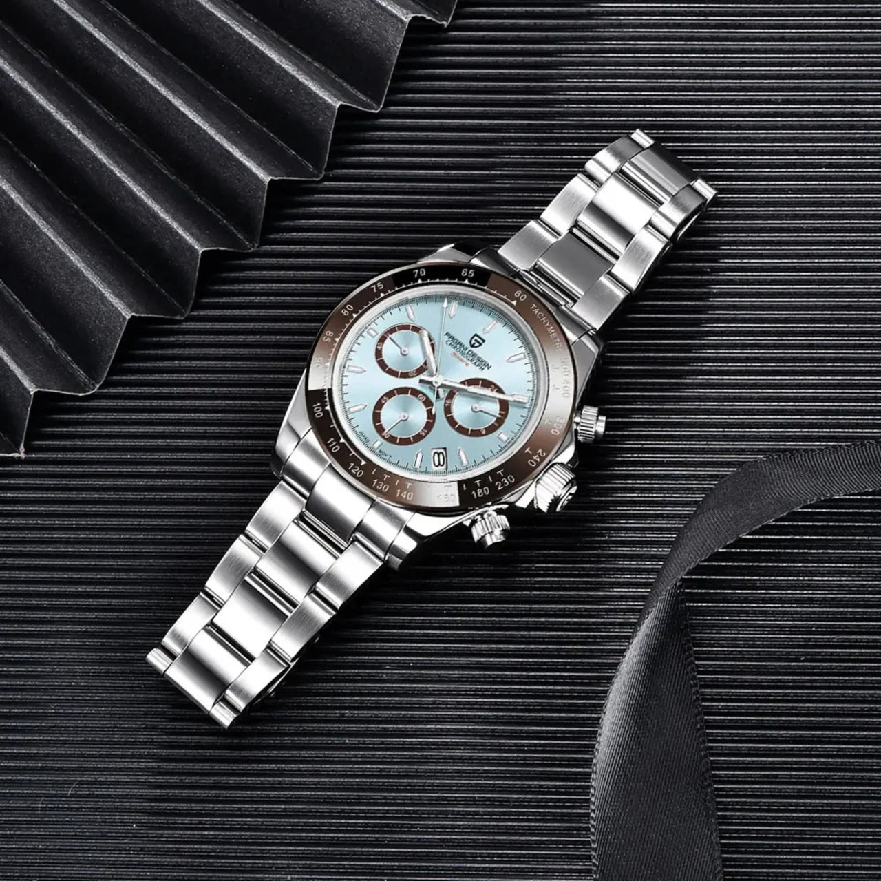 Silver watch with a detailed face on a textured black surface