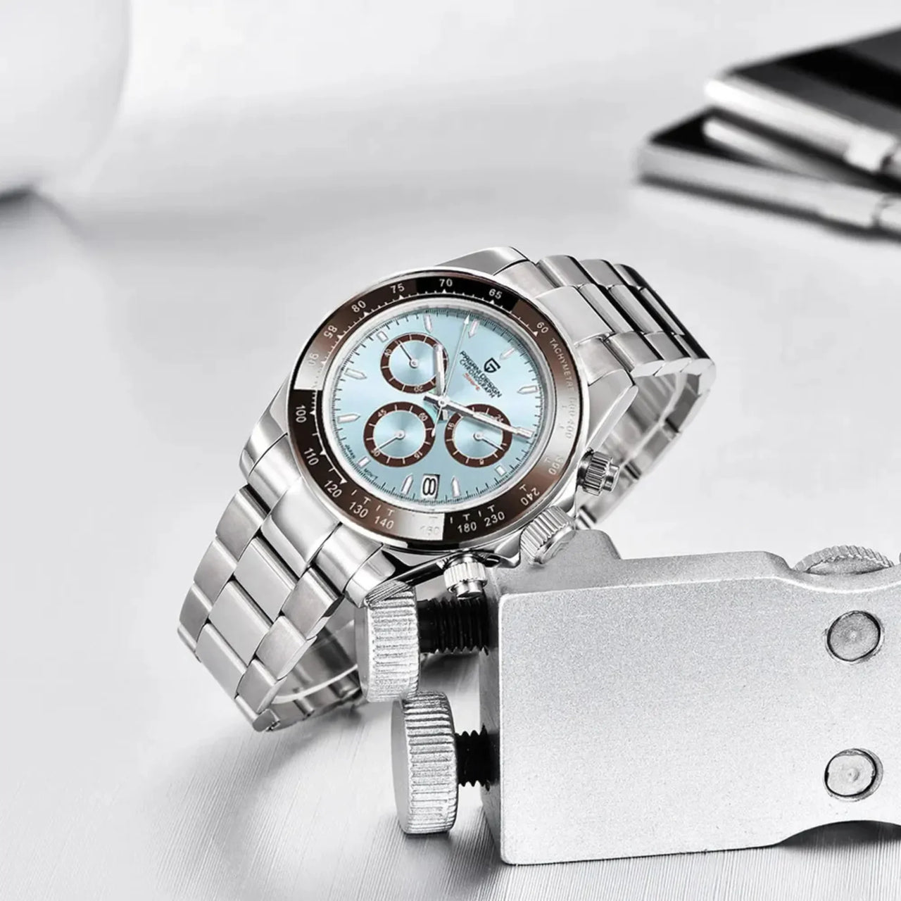 Silver watch with a light blue face on a white surface