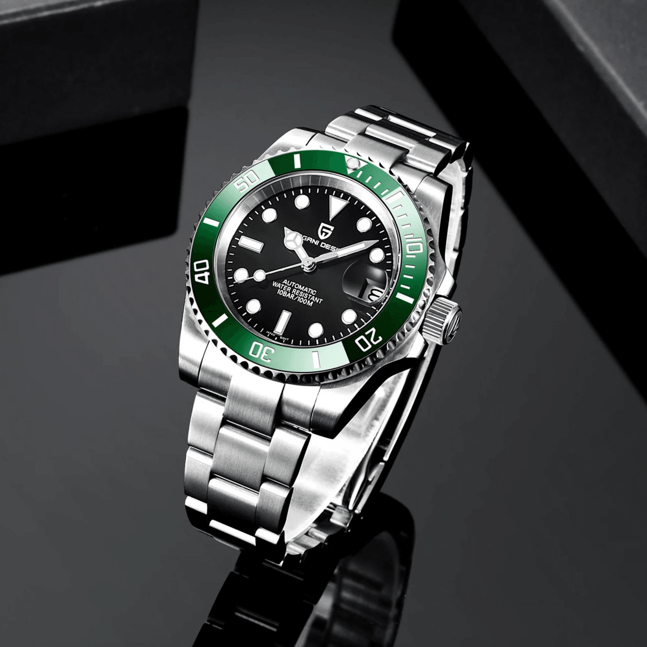Wristwatch with green bezel and black face on a reflective black surface