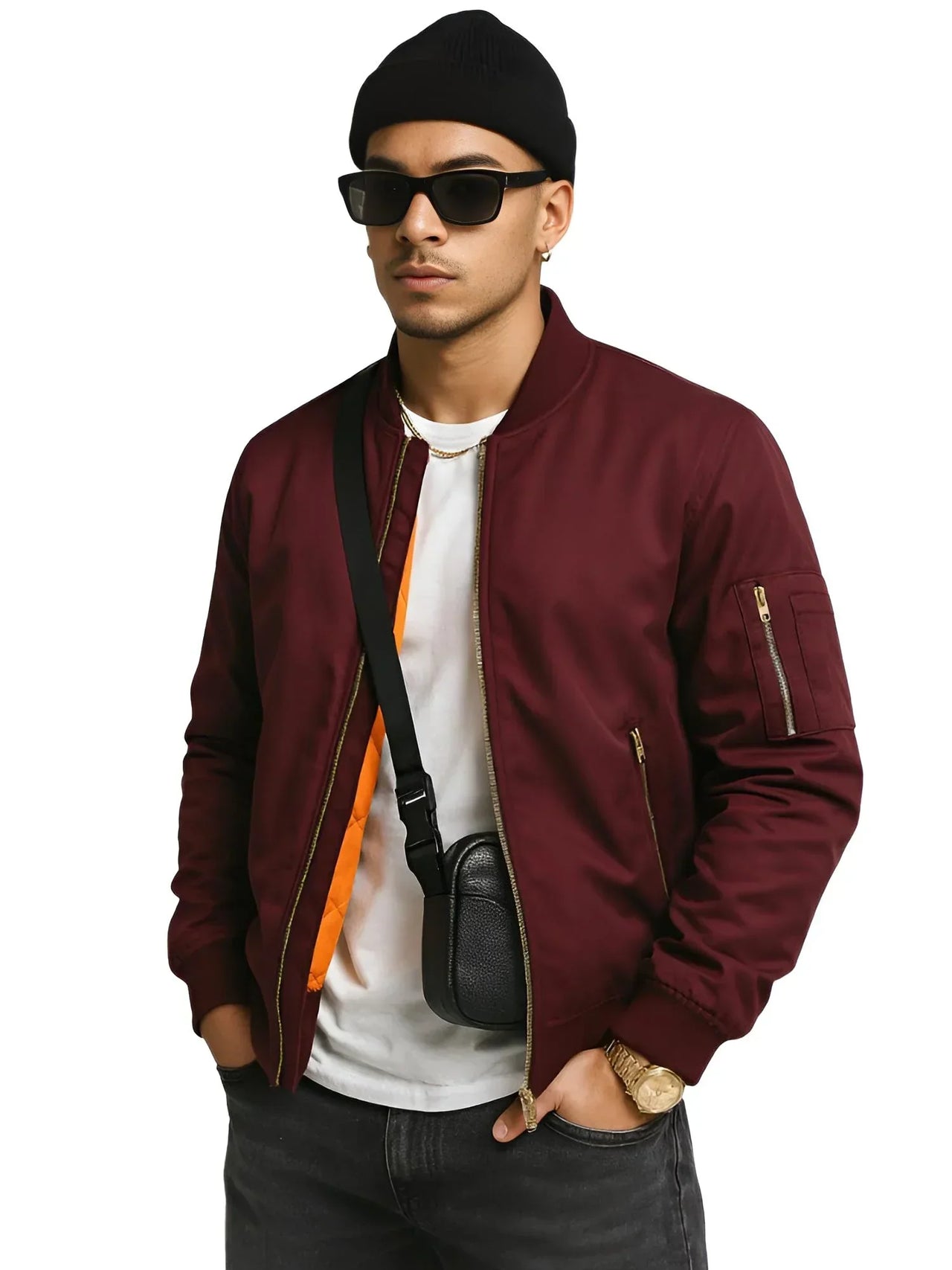 Man wearing a burgundy bomber jacket, black sunglasses, and a black beanie on a white background