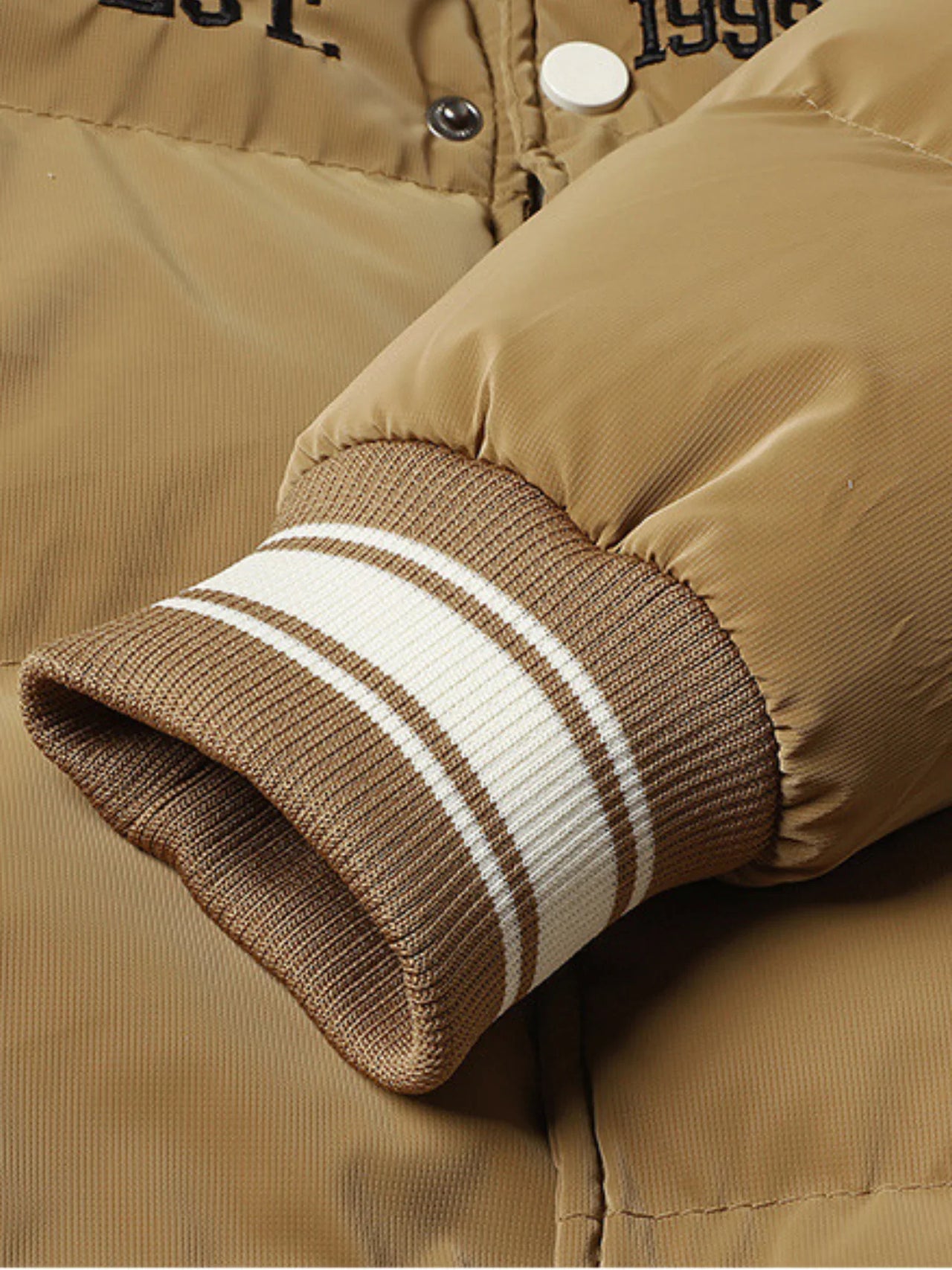 Close-up of a brown jacket with striped cuffs