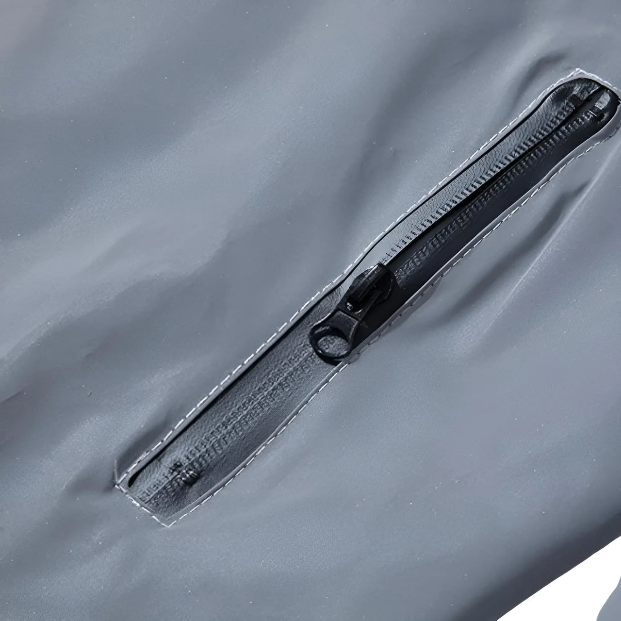 Close-up of a black zipper on a gray reflective jacket