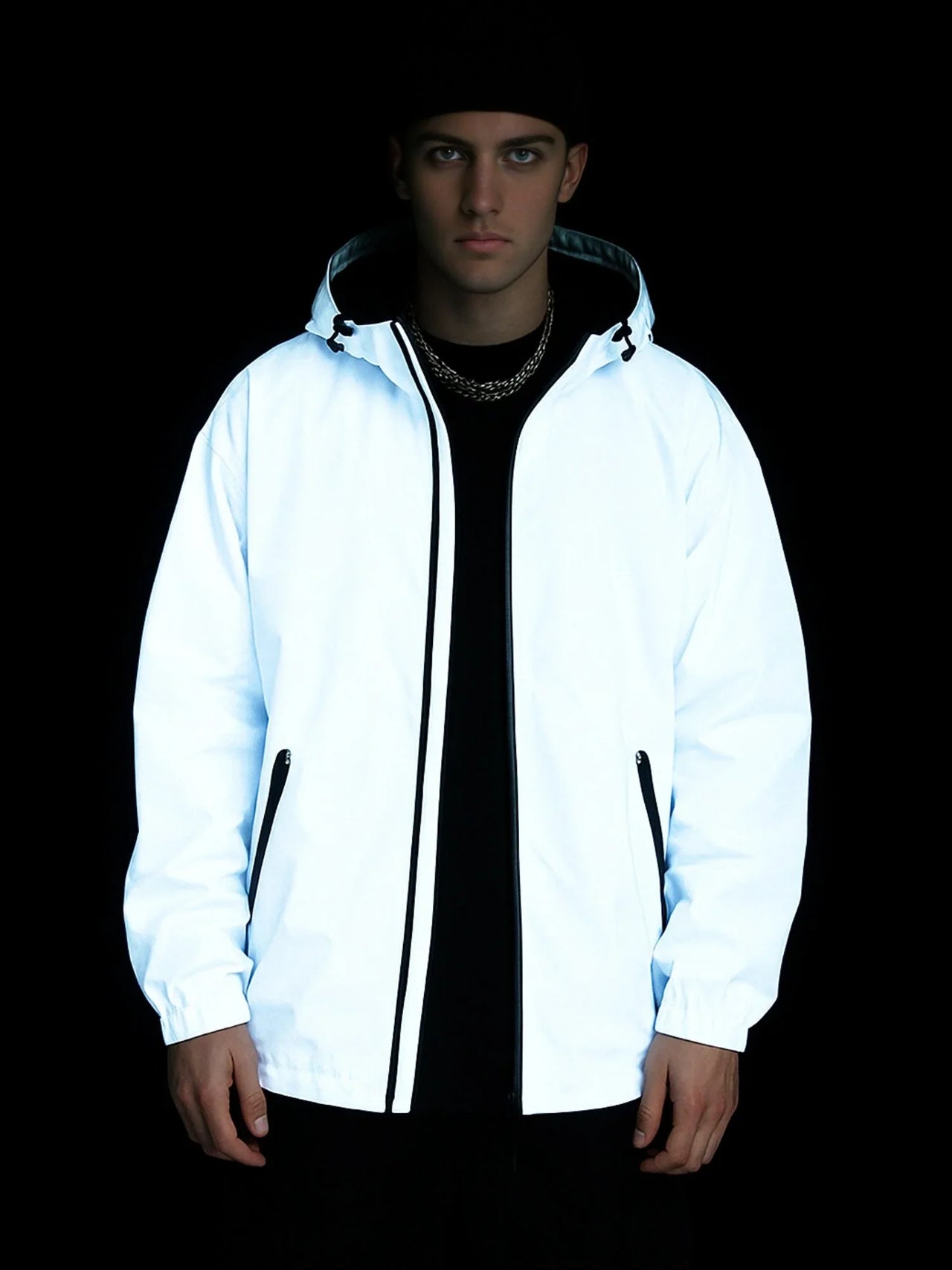 Person wearing a white jacket with black accents on a black background