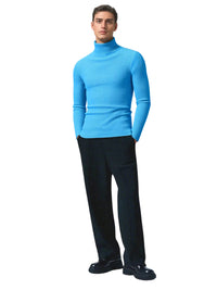 Thumbnail for Man wearing a bright sky blue turtleneck sweater and black pants on a white background