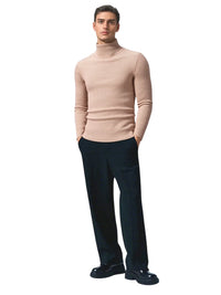 Thumbnail for Man wearing a khaki turtleneck sweater and black pants on a white background