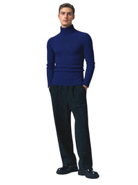 Thumbnail for Man wearing a navy blue turtleneck sweater and black pants on a white background