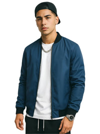 Thumbnail for Man wearing a blue bomber jacket, white shirt, black pants, and black cap on a white background