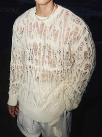 Thumbnail for Man wearing a white distressed sweater against a dark background