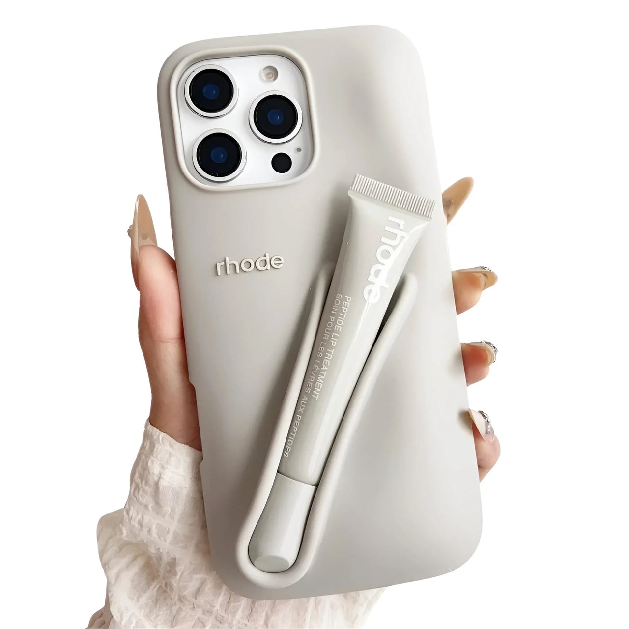 Grey silicone lipstick iPhone case with a matching lip gloss attached, branded 'rhode', held by a hand.
