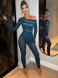 Thumbnail for Woman wearing a blue sparkly jumpsuit standing in a room with a mirror reflection.