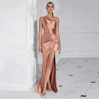 Thumbnail for Woman wearing a rose good one-shoulder draped maxi dress with a high slit in a white room.