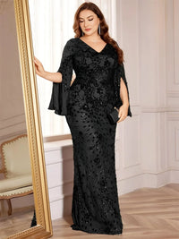 Thumbnail for Woman in a black evening gown standing next to a mirror in an elegant room.