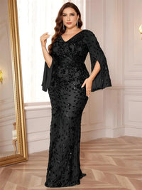 Thumbnail for Woman wearing a black evening gown with cape sleeves in an elegant room.