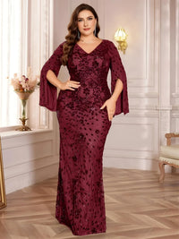 Thumbnail for Plus size woman wearing a burgundy evening gown with floral lace details in an elegant room.