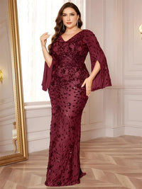 Thumbnail for Woman wearing a plus size burgundy evening gown with floral patterns in a room with a mirror and wooden floor.