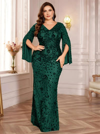 Thumbnail for Plus size woman wearing a dark green evening gown with floral patterns in an elegant room.