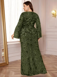 Thumbnail for Plus size woman in an olive green evening gown standing next to a mirror in an elegant room.