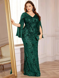 Thumbnail for Woman wearing a dark green plus size evening gown with floral patterns in an elegant room.