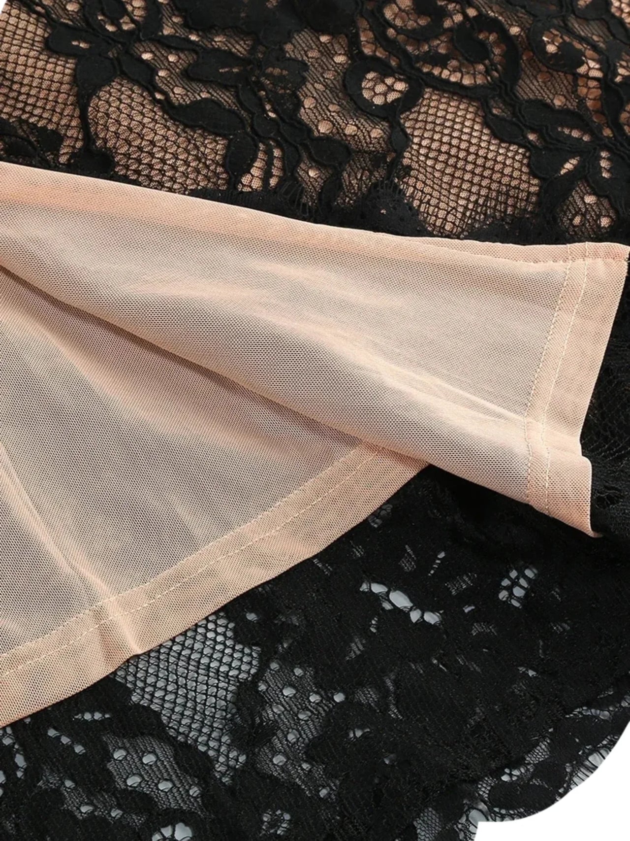 Close-up of black lace fabric with beige mesh lining